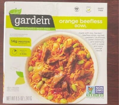 ORANGE BEEFLESS MADE WITH GARDEIN BEEFLESS STRIPS, RED BELL PEPPERS, CAULIFLOWER, WATER CHESTNUTS AND EDAMAME OVER RICE WITH A SWEET AND SPICY ORANGE SAUCE BOWL, ORANGE BEEFLESS